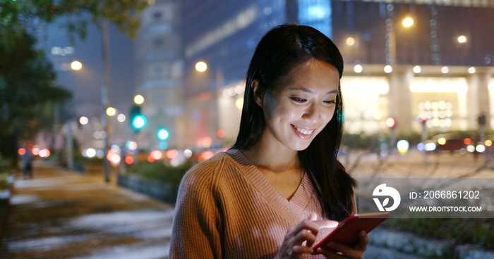 Woman check on cellphone in the street