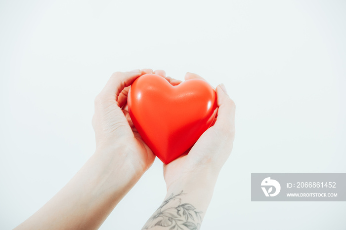 cropped view of woman holding plastic heart isolated on white