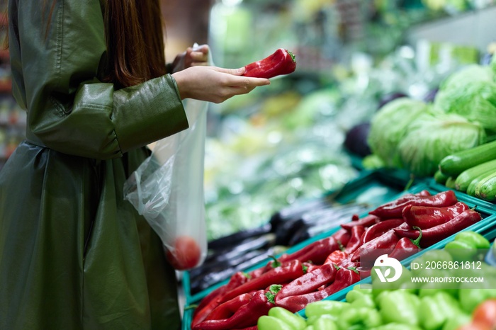 Woman at the grocery store picking fresh vegetables to cook for dinner, shopping