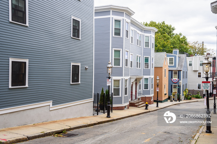 Deserted street lined with historic colourful wooden houses on a cloudy autumn day. Charlestown, MA, USA.