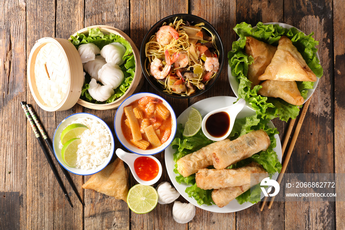 selection of asian food- spring roll, samosa, fried noodles, soup, rice and dumpling