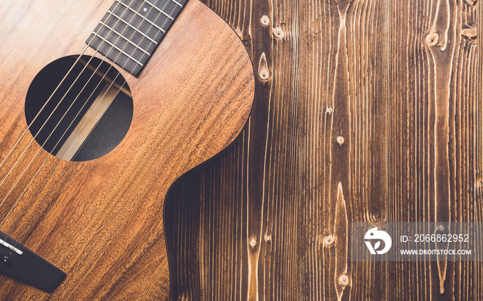 New brown guitar on wooden board