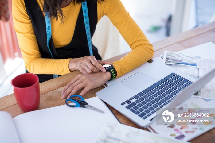 Female designer adjusting smart watch