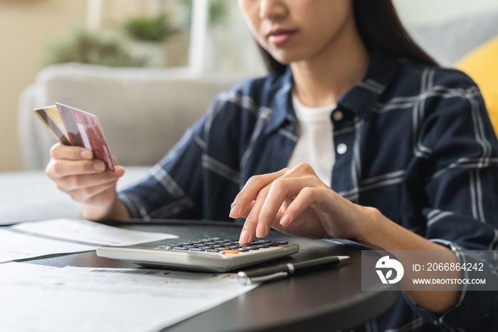 Business financial concept, stressed asian young business woman using calculator for calculate accounting expense of bill, tax for payment on due deadline, trying to find money to pay credit card debt