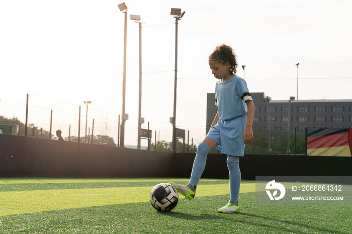 Girl (6-7) playing soccer on soccer field