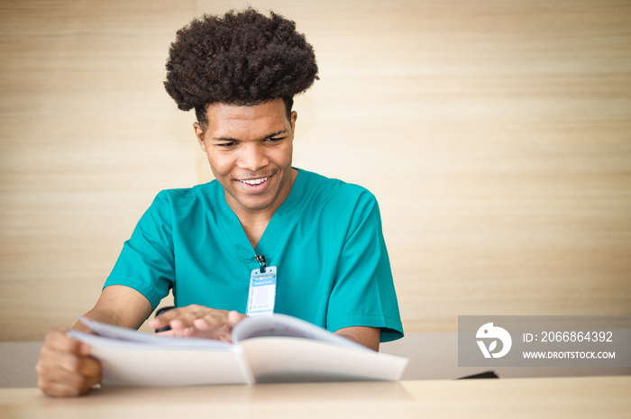 American medical student is reading a book to prepare for an exam in a hospital.