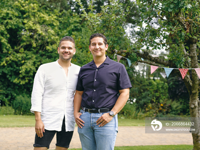 Portrait of smiling brothers standing in garden