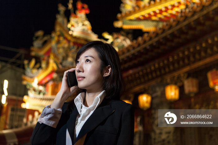 Businesswoman on cellular phone, night market, Taipei, Taiwan