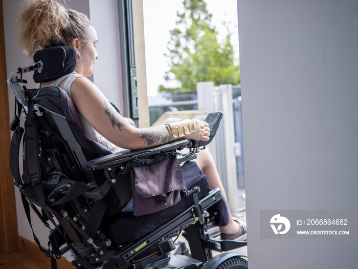 Woman in electric wheelchair going through front door