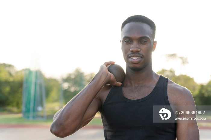 Portrait of athlete holding shot put