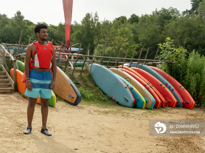 Man standing on beach before paddleboarding