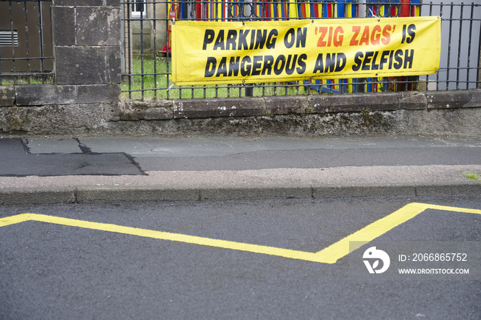 Parking on zig zags is dangerous and selfish sign outside school for children road safety