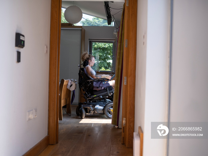 Woman in electric wheelchair at home