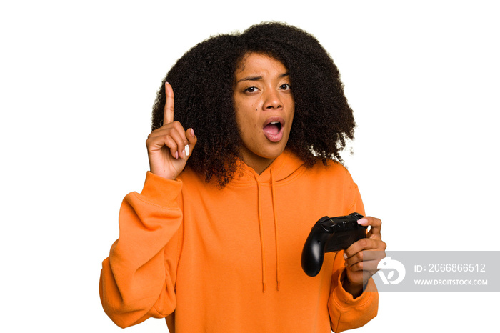 Young African American woman holding a game controller isolated having an idea, inspiration concept.