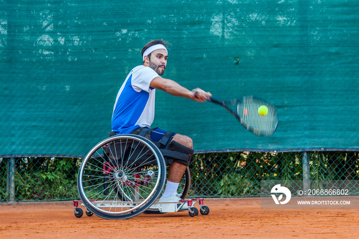 disabled tennis player hits the ball backhand