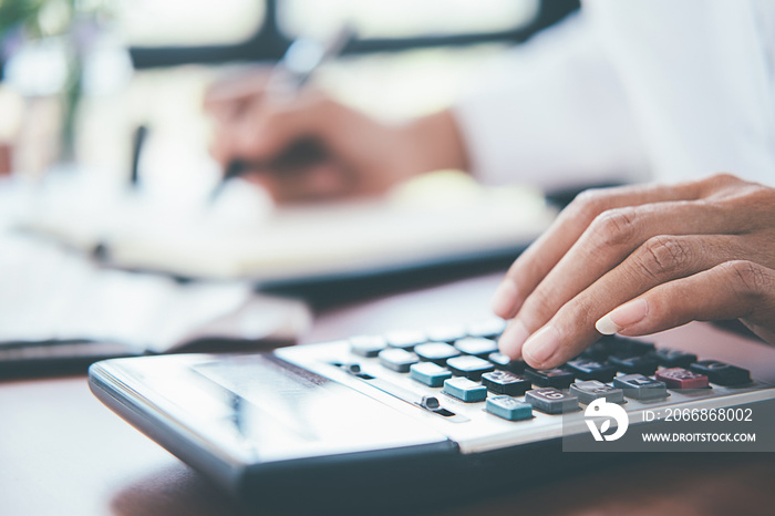 Woman with bills and calculator. Woman using calculator to calculate bills at the table in office. Calculation of costs.