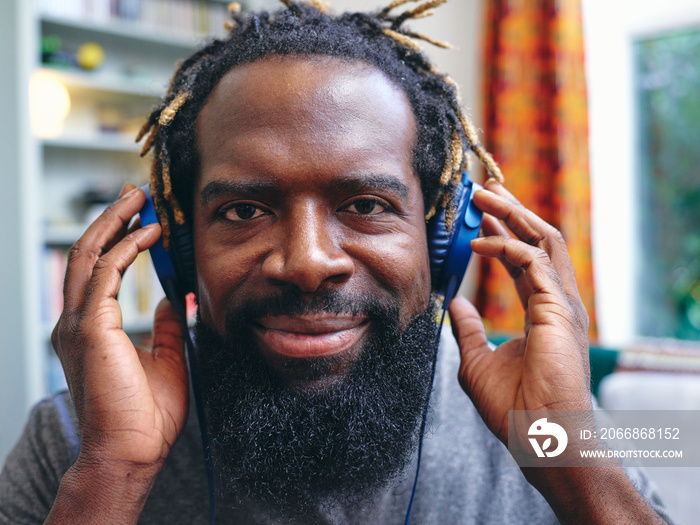 Portrait of man listening to music on headphones