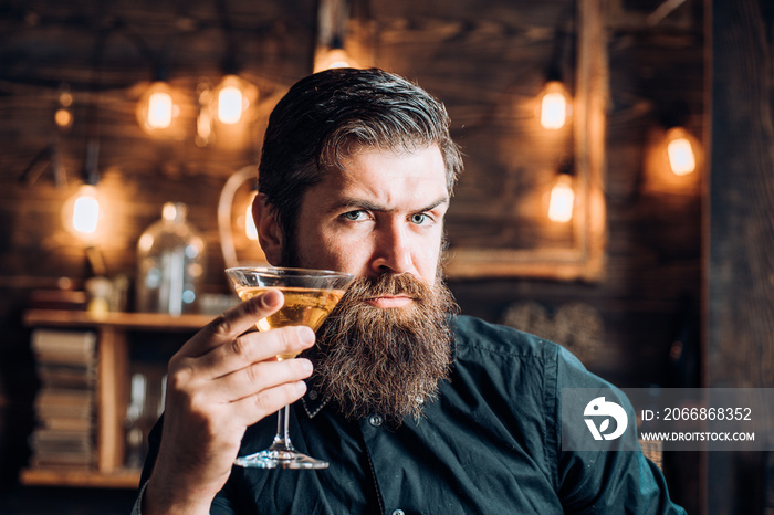 Retro bar. Bearded man sitting at bar. Handsome man drinking olcohol while sitting at the bar.