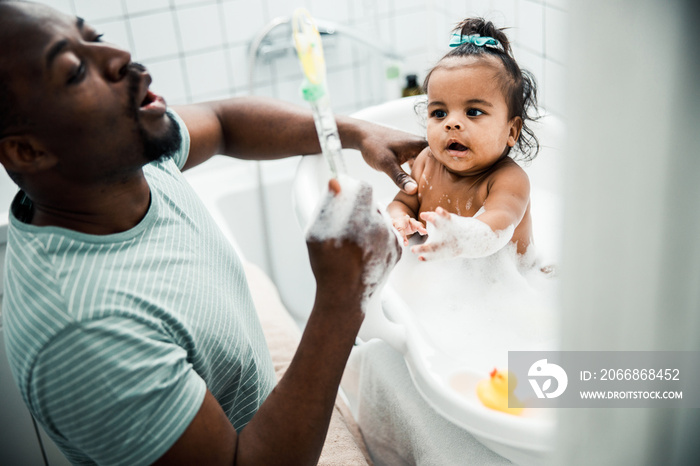 Cute newborn child taking bath and playing with daddy