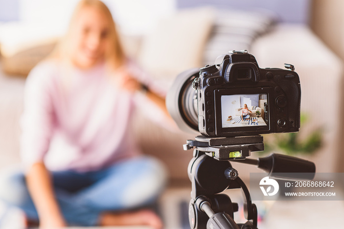 Cheerful female blogger recording video