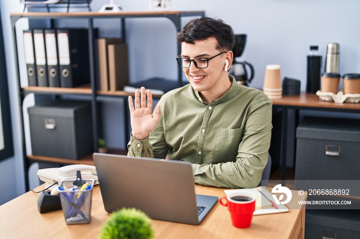 Non binary person working at the office wearing glasses looking positive and happy standing and smiling with a confident smile showing teeth