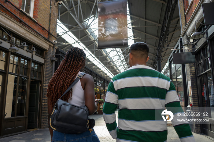 Back view of friends walking in market