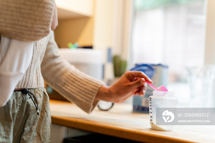 Woman preparing baby formula at home