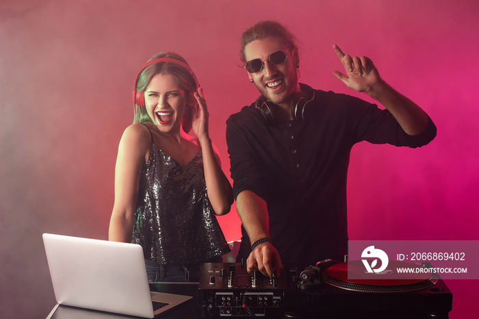 Young djs playing music in nightclub