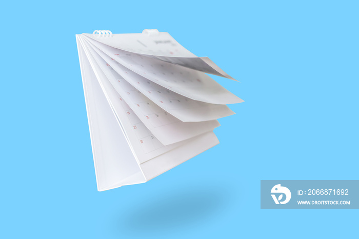 White paper desk calendar flipping page isolated on blue background