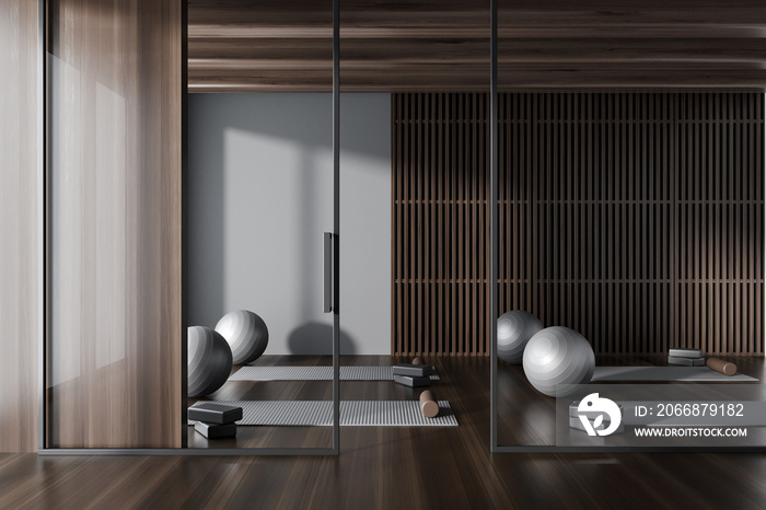 Modern gym class interior with sport equipment behind glass partition