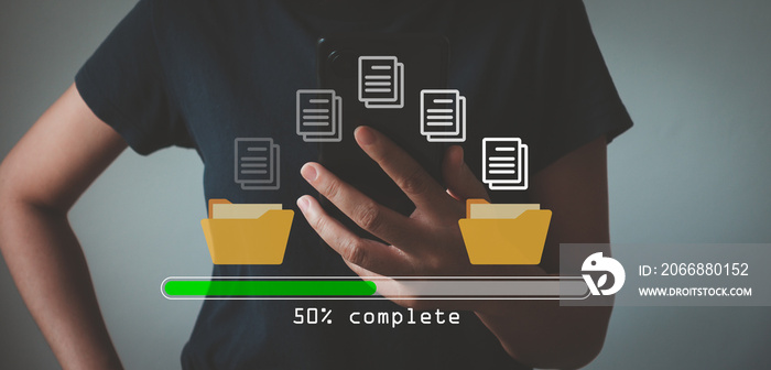 Data transfer concept. Copy files, data exchange, Files transfer. Person hand using mobile smart phone waiting for transfer file process with loading bar icon on virtual screen.