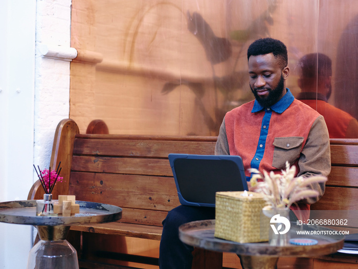 UK, London, Businessman using laptop in creative studio