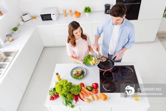 Top above high angle view of his he her she two nice attractive cheerful focused spouses spending time quarantine preparing domestic dish restaurant in light white interior kitchen house apartment