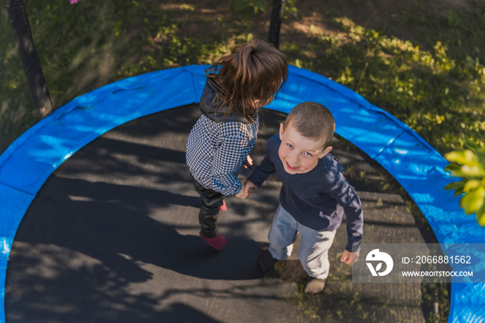 top view of small children jumping on a trampoline