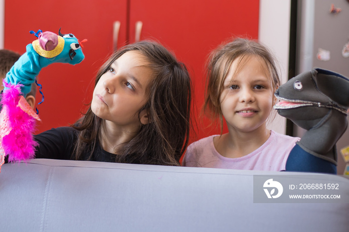 two young girls playing with puppets