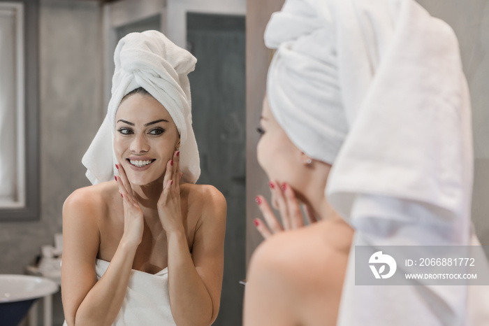 Cheerful female touching face after shower