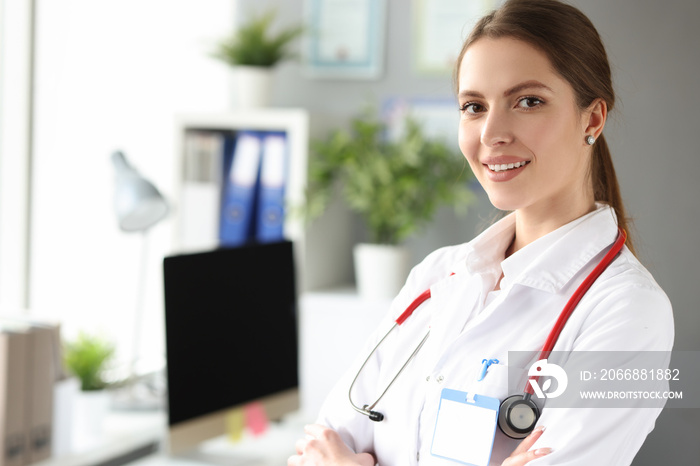 Portrait of young beautiful woman doctor in white coat in office