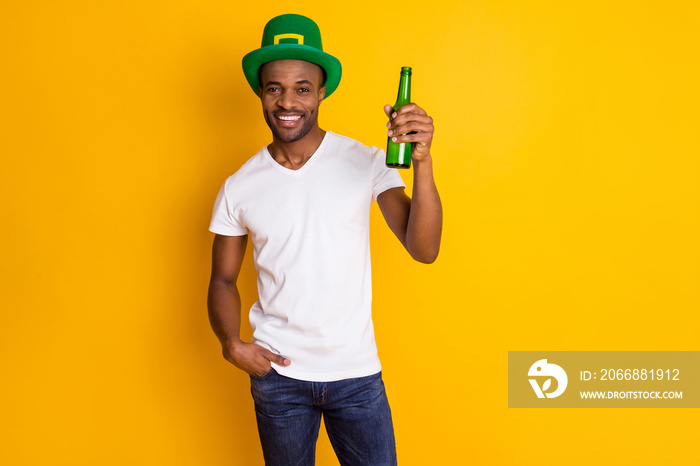 Cheers buddies. Photo of attractive dark skin guy hold beer beverage bottle students party saint patrick day wear casual white t-shirt isolated bright vivid yellow color background