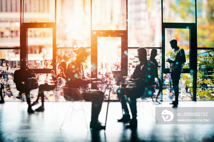 Background concept with business people silhouette working in the office near a window glass. Double exposure and light effects