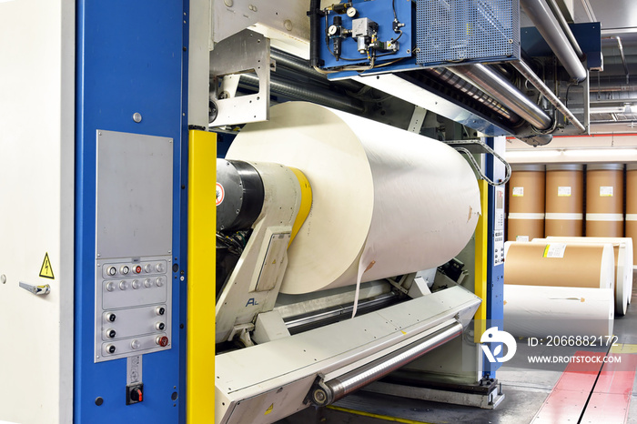 moderne Off-Set-Druckmaschine mit einer Papierrolle in einer Druckerei für Tageszeitungen // Modern off-set printing machine with a paper roll in a print shop for daily newspapers