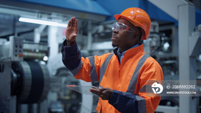 Analyst using modern glass tablet computer at machinery factory. Hitech concept