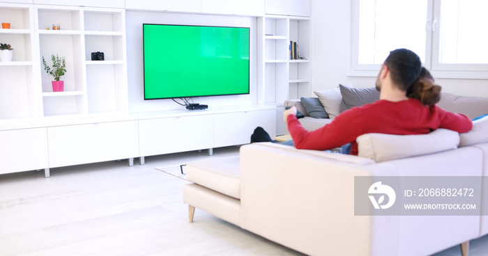 Young couple on the sofa watching television