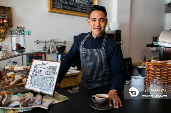 Hispanic barista serving a coffee