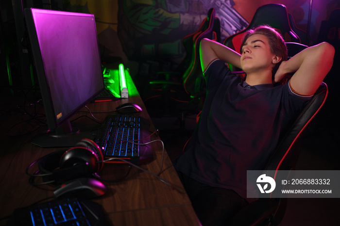 Cyber sport. Rrelaxed player rests in the break between matches on his comfortable gaming chair