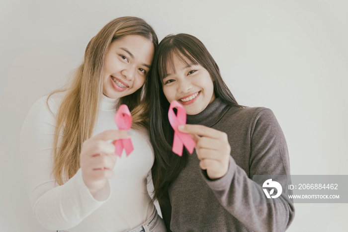 Young Asian women with pink ribbons, breast cancer awareness, October pink concept, world cancer day