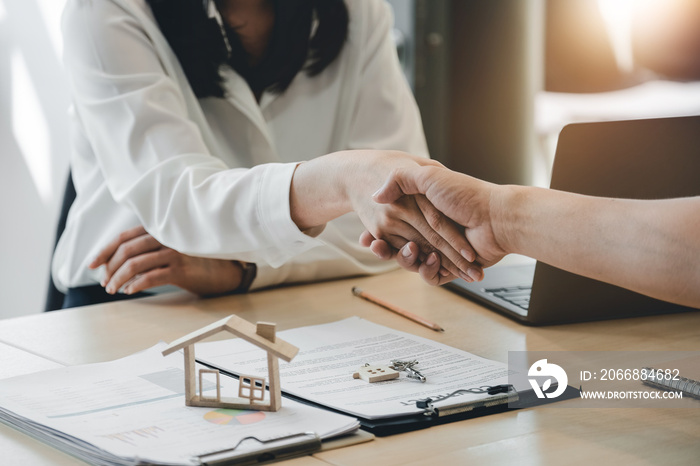 Estate agent and customer shaking hands after finished contract after about home insurance and investment loan.