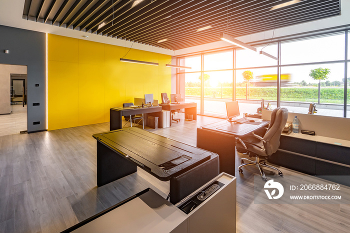 Modern office space with tables and chairs, computers and office supplies with no employees