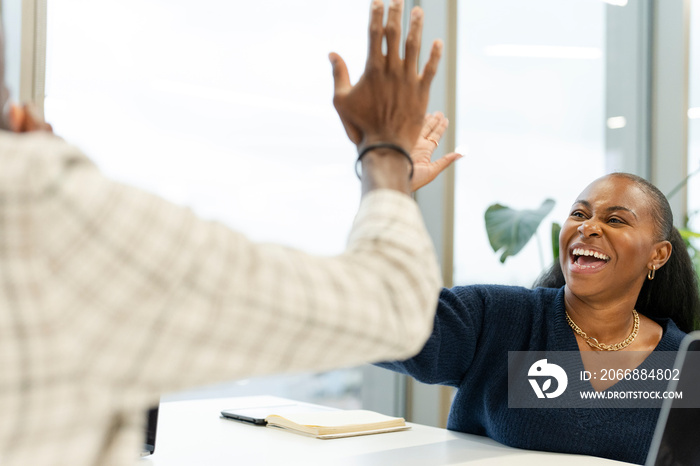 Business people high-fiving in office