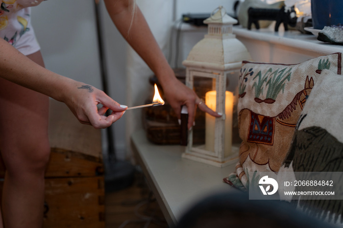 Woman igniting candle in lantern