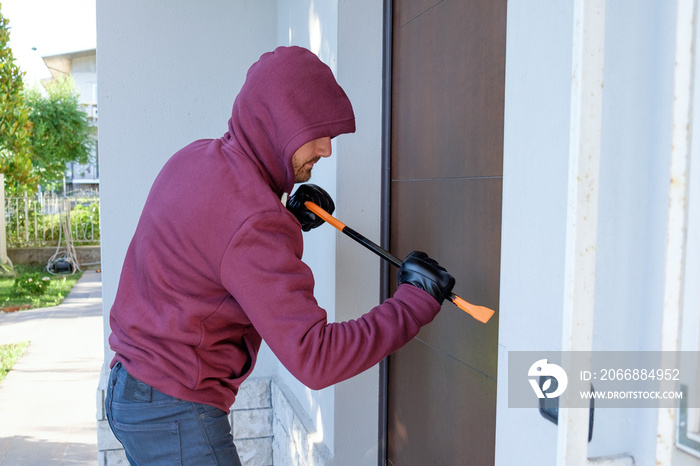 Burglar trying to force a door lock using a crowbar